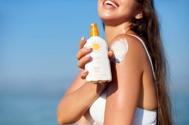  Thoulder 'a güneş kremi süren Bikini' li güzel kadın. Deri ve Vücut Bakımı. Cilt İçin Güneş kremi Kullanan Kız