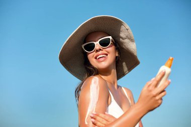 Thoulder 'a Bikini Güneş Kremi süren Güzel Kadın. Güneş koruması. Deri ve Vücut Bakımı. Güneş kremini ten rengine kullanan kız. Güneş losyonu ve nemlendirici güneş kremi tutan kadın portresi