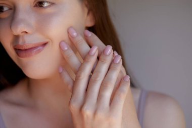 Sağlıklı cilt ve manikürlü güzel bir genç kadın. Kadın Doğal Makyajı ve El Kozmetikleri Bakımı. Manikür ve Eller Spa. Kozmetoloji, Güzellik. Deri Araba