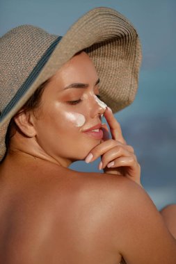Güneş kremi süren güneş kremi süren güneş kremi kullanan kadın. Cilt bakımı. Güneş koruması