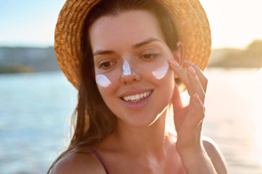 Güzellik kadını Wirh bronz spf ve cilt bakım modeli yüz portresi nemlendirici kremi, güneş kremi ya da yanağında güneş kremi olan kadın, lüks yüz bakımı ve cilt bakımı.