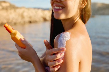 Güneş kremi ve güneş kremi. Kadın güzel yaz günü gülümseyerek burun güneş kremi koyarak. Skincare. Güneş kremi uygulayan kız. Güneş