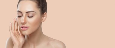 Beautiful Woman with healthy smooth facial clean skin holding bottle cosmetic cream. Panorama With Copy Space