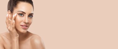 Beauty face model. Beautiful Woman with healthy smooth facial clean skin holding bottle cosmetic cream. Face Skin care Moisturizer Facial treatment. Panorama baner With Copy Space
