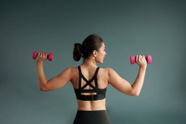 Domestic Training With Weights.Woman doing exercises with dumbbells, strengthening her body at home.