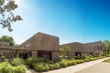 Residential area with ecological and sustainable green residential buildings, low-energy houses with wooden facade, timber construction and green courtyard