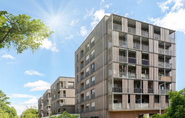 Residential area with ecological and sustainable green residential buildings, low-energy houses with wooden facade, timber construction and green courtyard