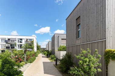 Residential area with ecological and sustainable green residential buildings, low-energy houses with wooden facade, timber construction and green courtyard