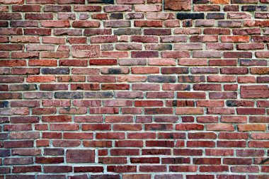 Kırsal Kırmızı Tuğla Duvar dokusu. Kırsal kırmızı tuğla bir duvarın detaylı bir görüntüsü çeşitli gölgeler ve dokular sergiliyor.