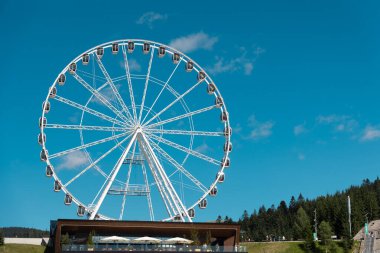 Güneşli bir günde dönme dolap. Güneşli bir günde bir dönme dolap açık mavi bir gökyüzüne çarpar.