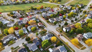 Sonbahar Renkleriyle Konut Apartmanı 'nın Hava Görüntüsü. Geniş bahçeli evler, rengarenk sonbahar ağaçları, düzenli caddeleri gösteren bir apartman dairesinin yüksek açılı görüntüsü.