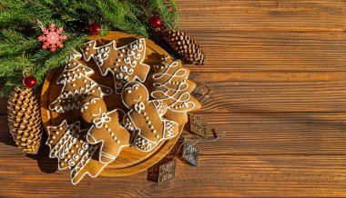 Christmas gingerbread cookies on rustic wooden table. Festive gingerbread cookies shaped like trees and gingerbread men with icing. Top view. Free space for text clipart