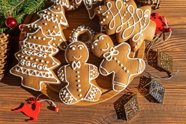 Bayram süslemeleri ile süslü zencefilli kurabiye. Ağaçlar ve insanlar şeklinde güzel dekore edilmiş zencefilli kurabiye koleksiyonu.