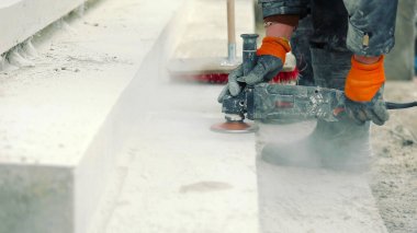 İnşaat İşçisi Güç Aracı ile Beton Yüzeyi Yumuşatıyor. Bir inşaat işçisi beton yüzeyi pürüzsüz hale getirmek için öğütücü kullanır.