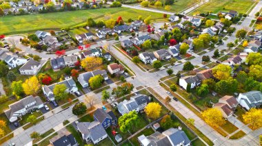 Sonbaharda bir banliyö mahallesinin hava görüntüsü. Sonbaharda bir banliyö mahallesinin canlı hava görüntüsü, renkli ağaçlar, düzgün düzenlenmiş evler, yollar ve yakınlardaki açık yeşil alan.