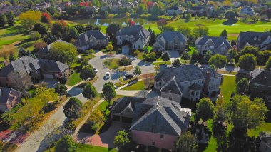 Chicago, Illinois yakınlarındaki lüks bir banliyö mahallesinin insansız hava aracı görüntüsü. Geniş evleri, dairesel sokakları ve golf sahası var.