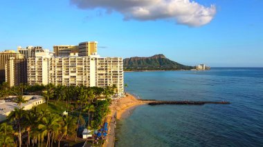 Waikiki Sahili, Diamond Head manzaralı, yüksek katlı otelleri ve mavi okyanusları olan tropikal bir yer.