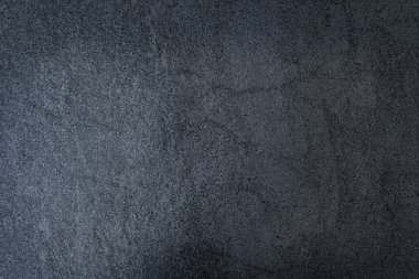 Koyu gri desenli beton yüzey. Koyu gri beton bir yüzeye yakın çekim, pürüzlü ve desenli bir kaplama. Üst Manzara. Metnin için boş yer