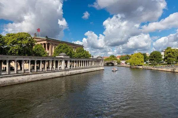 Berlin, 26.05.2025, Müze Adası ve Nehir Spree, Güneşli Gün. Berlin 'deki Müze Adası manzarası. Spree Nehri boyunca klasik sütunlar ve mavi gökyüzünün altında yüzen bir tekne.