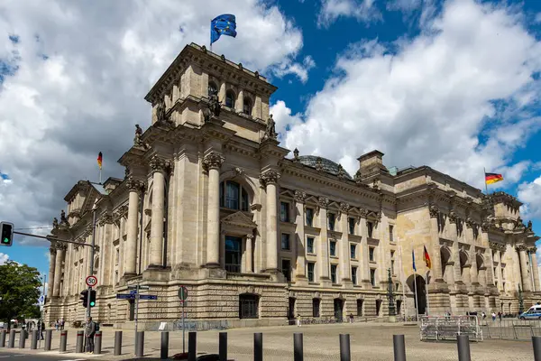 Almanya, Berlin, 26.05.2025, Alman Reichstag binası, mavi gökyüzünün altında bayraklar. Almanya 'nın Berlin kentindeki tarihi Reichstag binası Alman ve AB bayrakları dalgalanıyor
