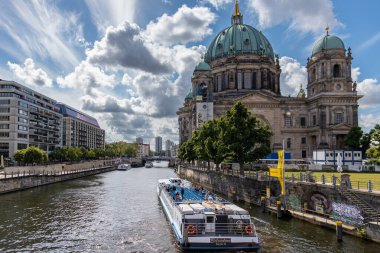Almanya, Berlin, 26.05.2025 Berlin Katedrali yakınlarındaki River Spree 'de bir tur botu. Güneşli bir günde Berlin Katedrali 'nin yanından geçen manzara nehir teknesi, Almanya' da tarihi mimari ve canlı şehir yaşamını gözler önüne seriyor.