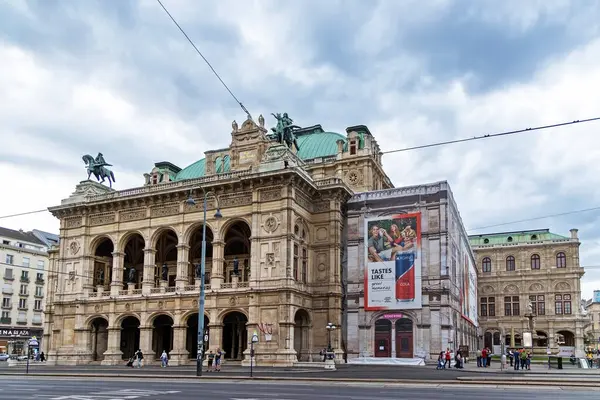 Viyana Devlet Operası, Viyana, Avusturya - 01 Ağustos, 2025. Sokak manzaralı Viyana Devlet Opera binası. Sokakta görülen tarihi Viyana Devlet Operası bulutlu bir günde neo-rönesans mimarisi, heykeller ve turistlerin sergilendiği bir yer..