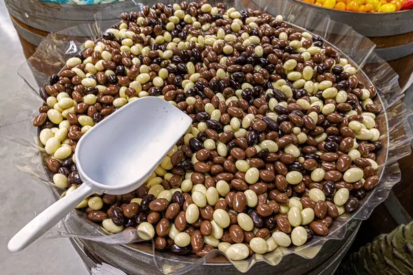 Çukulata kaplı fındıklar. Koyu, süt ve çikolata kaplı fındık dolu büyük tahta fıçı. Kendi kendine şeker almak için bir kepçe.