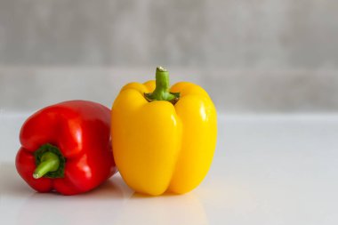 red and yellow sweet peppers on a gray background copyspace