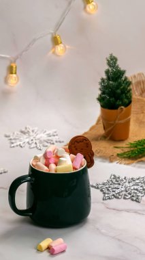 Kakao ve marşmelovlu bir fincan. Fincanda zencefilli kurabiye. dikey