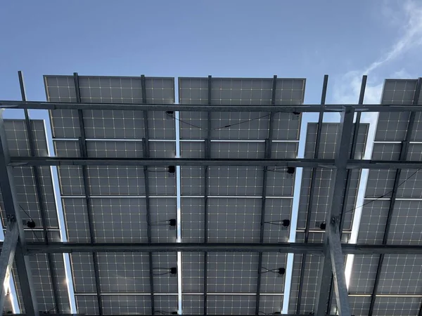 Mavi gökyüzüne karşı güneş panelleri. Elektrik üretimi için fotovoltaik paneller.