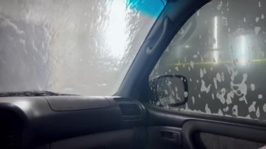 Otomatik yıkama devrede. Otomatik köpüklü araba yıkama. Basınç altında araba yıkama, araba yıkama köpük suyla yıkama, temiz su. Konsept araba.