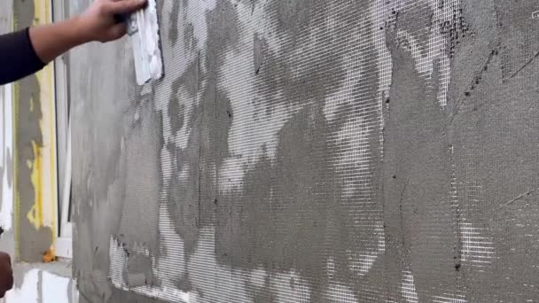 用油灰刀 把油灰涂在墙上 涂一层油灰的过程 一个人用聚苯乙烯把大楼隔热后 有人在正面贴上了石膏 能源概念 — 图库视频影像