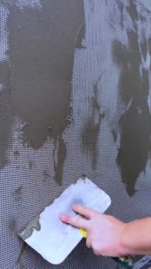 Elle boyanmış bir duvarın yakın plan görüntüsü. Duvarın dekorasyonu bitmeden önce ön cephe takviye ağı devreye sokulur. Dairelerin tamiri, yerleşim yerleri. Duvarları onar..