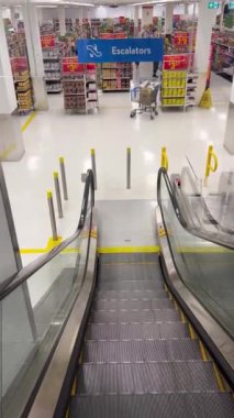 Alışveriş merkezi yürüyen merdiveni. 5.10.23 Mississauga Kanada. Müşteriler için yürüyen merdiven. Bir alışveriş arabası alışverişlerle birlikte duruyor. Müşteriler için güvenlik ve kolaylık kavramı. Asansör yürüyen merdiven.