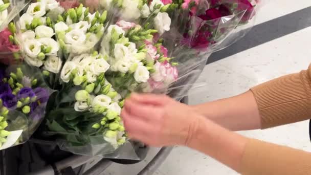 Κοντινό Πλάνο Των Γυναικείων Χεριών Επιλέγοντας Ένα Μπουκέτο Λουλούδια Ευστώματος — Αρχείο Βίντεο