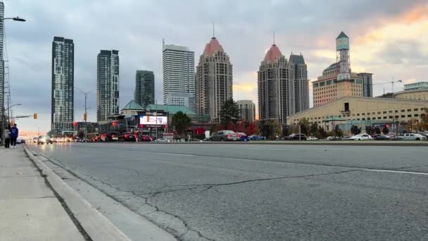 カナダ ミシッサガ オンタリオ州の近代的な建物を通る道 イブニングシティ 現代都市の風景 サンセットでのモダンな快適な都市 ヘッドライト付きの車の流れ イギリス — ストック動画