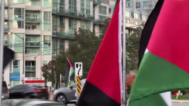 Filistin 'in bayrakları yükselen binaların arka planında dalgalanır. Savaşa karşı barışçıl bir protesto. Kanada 'da Filistin mitingleri 28 Ekim 2023, Ontario' da savaşa karşı sokak mitingleri