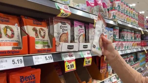23加拿大米沙加 选择在商店里的米 在商店柜台上打折米 超市里的一位欧洲妇女选择了糙米和茉莉花米 购买健康食品的概念 — 图库视频影像