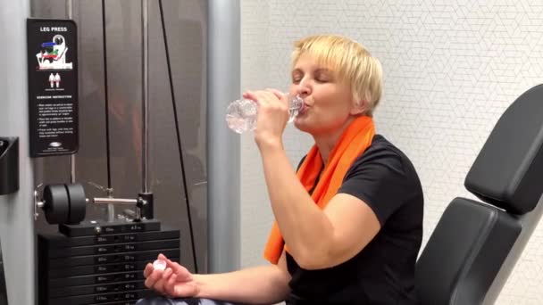 Una Mujer Simulador Descansa Bebe Agua Cámara Lenta Gimnasio — Vídeo de stock