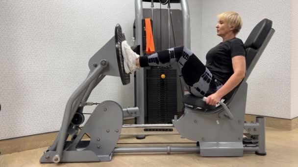 Spor Salonundaki Yaşlı Bir Kadın Bacak Makinesinde Çalışıyor Bacak Baskısı — Stok video