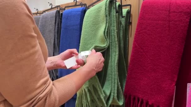 여자는 센터에서 따뜻한 스카프를 클로즈업 매장에서 액세서리를 고객의 움직임 — 비디오