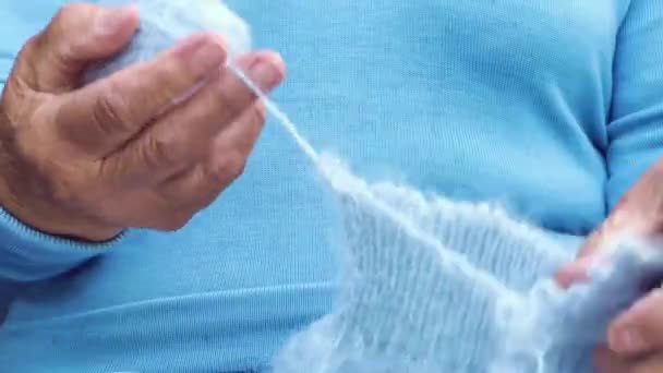 女性は新しい暖かい服のための糸を準備します リサイクルという概念 古いものへの新しい命 彼女の手で編む女性 針仕事をしている老婆の手 青い女性が溶ける — ストック動画
