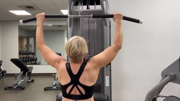 Yetişkin Bir Beyaz Kadın Spor Salonundaki Bir Makinede Barfiks Çekiyor — Stok video