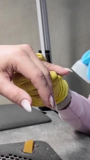 化粧品サロンでの手のサニタイザー治療 ジェルポリッシュを塗布する前にネイルプレートの準備 手の垂直クローズアップビデオ — ストック動画