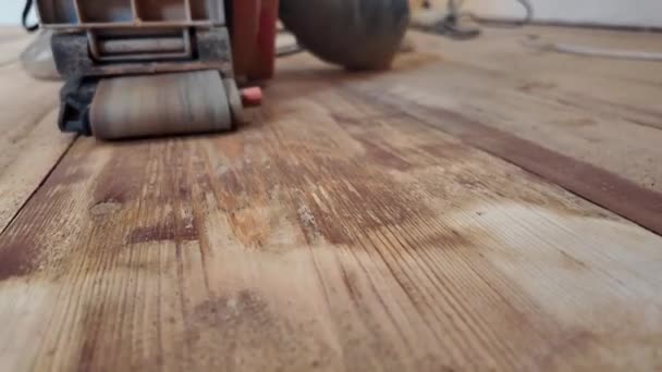 パワーツールを使用した木製の床の修理作業 アパートのリニューアル 古い木の表面を処理する 研削機クローズアップビデオ付きフロアサンディング — ストック動画