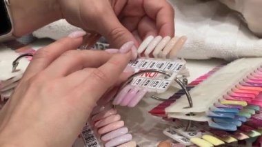 Mississauga Kanada 12.02.24. Güzellik salonunda manikür servisi. Bir kadın yeni manikür için oje rengini seçer. Güzellik ve moda konsepti.