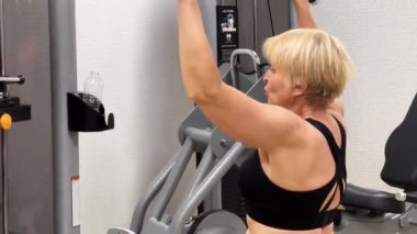 Spor salonundaki bir halat makinesinde çalışırken odaklanmış bir adam. Kavram: Fiziksel sağlık ve güç arayışı. Yatay video.