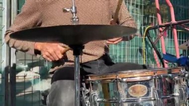 Sokak davulcusu. Davulcunun solo videosu. Bir müzisyen becerikli bir şekilde sokakta renkli ve yıpranmış bir davul çalar, şehir sanatını çağrıştırır. Kavram: Sokak performansı sergileniyor
