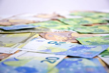 Çok sayıda Euro banknotunun yakın plan çekimi, 20 Euro 'luk banknota odaklanıyor. Resim para biriminin detaylarını ve renklerini yakalar.