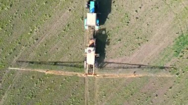 Büyük bir püskürtücü tarla boyunca ilerler ve sabah erken saatlerde ekinlere tedavi uygular. Ekipmanlar verimli bir şekilde zemin kaplıyor..